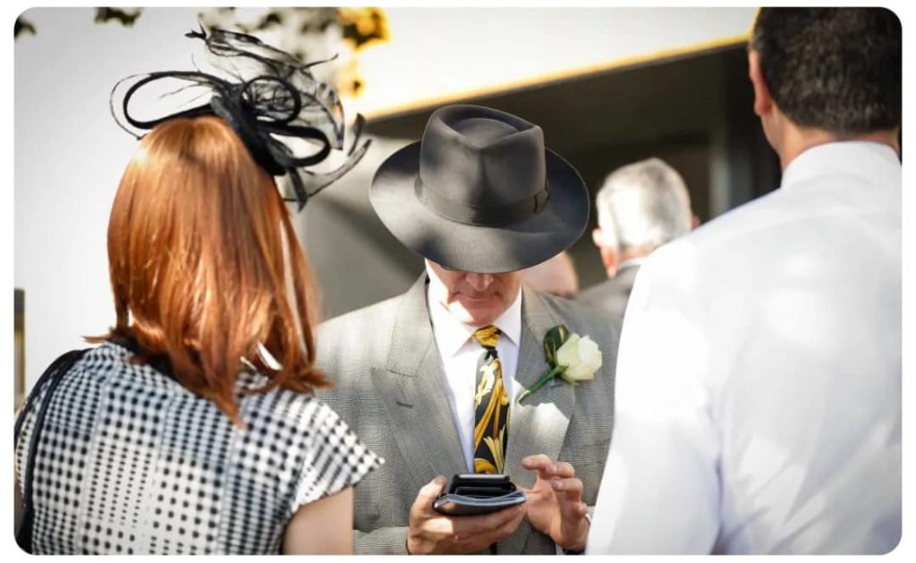 A man in a hat is looking at his phone.