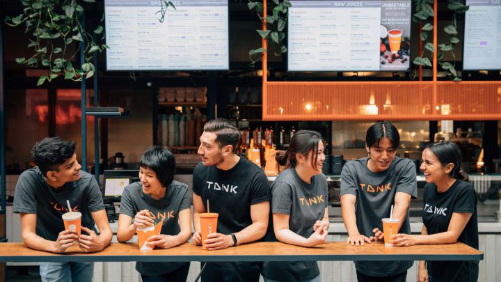 A group of TANK employees sat at TANK with drinks.