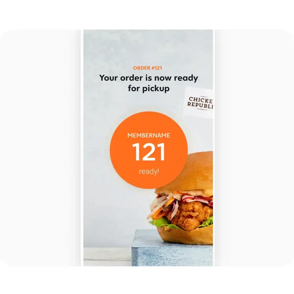 A mobile app showing a picture of a chicken burger and saying order 121 is ready for pick up.